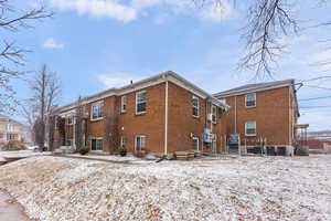 Snow covered property featuring cooling unit