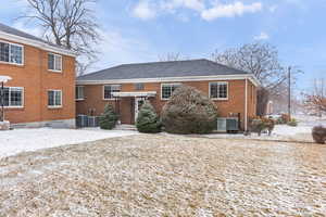 Snow covered house featuring central AC unit