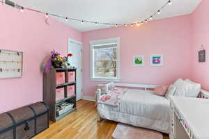 Bedroom with track lighting and light wood-type flooring