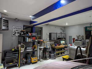 Garage with electric panel and a workshop area