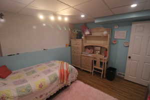 Bedroom with a paneled ceiling and dark hardwood / wood-style floors