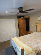 Bedroom with dark carpet, a closet, and ceiling fan