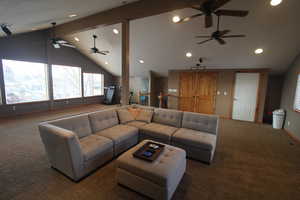 Living room with lofted ceiling and dark carpet