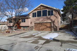 View of front of home with a garage and solar panels