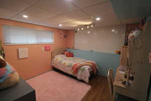 Bedroom featuring dark wood-type flooring and a drop ceiling