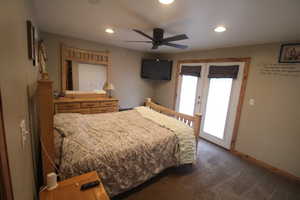 Carpeted bedroom with french doors, ceiling fan, and access to exterior