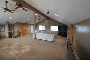 Unfurnished living room featuring vaulted ceiling and carpet