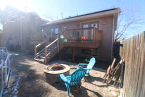 Rear view of house featuring a deck and an outdoor fire pit