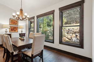 Dining area featuring an inviting chandelier and dark hardwood / wood-style floors