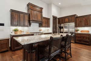 Kitchen featuring a kitchen island with sink, sink, a breakfast bar area, and stainless steel appliances