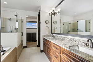 Bathroom with independent shower and bath, vanity, a notable chandelier, and tile patterned floors