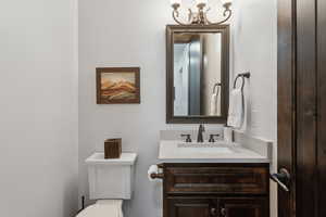 Bathroom featuring vanity, a chandelier, and toilet