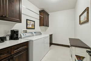 Washroom featuring cabinets and washer and dryer