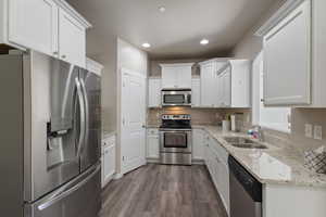 Kitchen featuring white cabinetry, appliances with stainless steel finishes, and sink