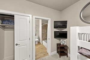 Bedroom with hardwood / wood-style flooring and connected bathroom