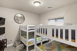 Bedroom featuring multiple windows, carpet floors, and a textured ceiling