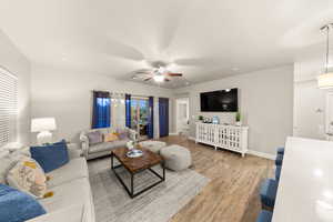 Living room with wood-type flooring and ceiling fan