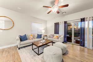 Living room featuring ceiling fan, light hardwood / wood-style flooring, and a textured ceiling