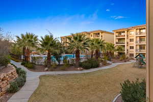 View of property's community with a swimming pool, a lawn, and a playground