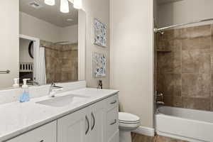 Full bathroom featuring vanity, hardwood / wood-style floors, toilet, and shower / tub combo with curtain