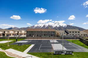 Exterior space featuring a yard, a mountain view, and tennis court