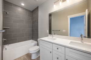 Full bathroom with vanity, hardwood / wood-style flooring, toilet, and tiled shower / bath