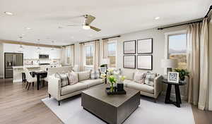 Living room with ceiling fan and light wood-type flooring