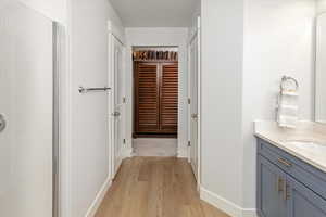 Bathroom with vanity, hardwood / wood-style flooring, and a shower with shower door