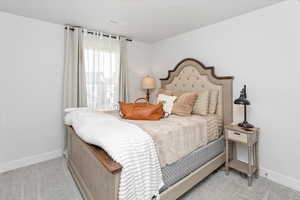 Bedroom featuring light colored carpet