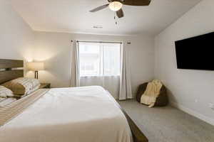 Carpeted bedroom with ceiling fan