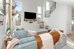 Living room featuring a towering ceiling, plenty of natural light, and hardwood / wood-style flooring