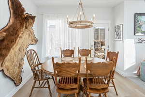 Dining area with light hardwood / wood-style flooring and a chandelier