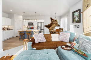 Living room with a notable chandelier and light wood-type flooring