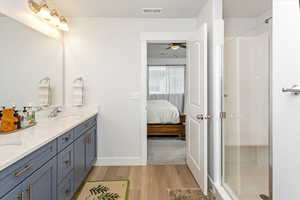 Bathroom featuring wood-type flooring, a shower with shower door, and vanity