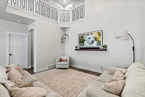 Living room with dark hardwood / wood-style floors and a high ceiling