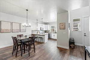 Dining area with an inviting chandelier and dark hardwood / wood-style flooring