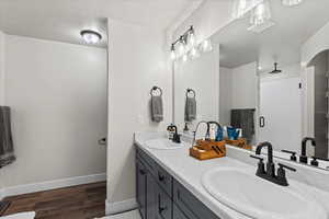 Bathroom featuring an enclosed shower, vanity, and wood-type flooring