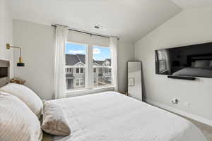 Carpeted bedroom featuring vaulted ceiling