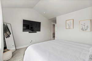 Carpeted bedroom featuring lofted ceiling