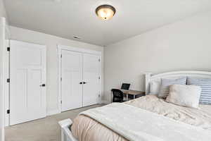 Carpeted bedroom with a closet