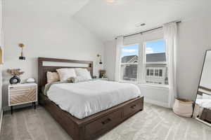 Carpeted bedroom featuring vaulted ceiling