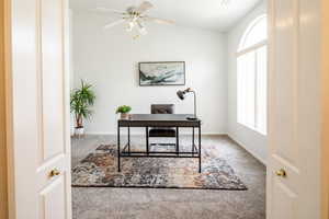 Carpeted office space with a wealth of natural light and ceiling fan