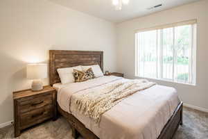 Bedroom with multiple windows, carpet, and ceiling fan