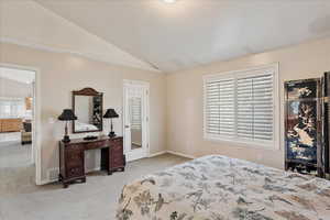 Bedroom featuring vaulted ceiling and light colored carpet