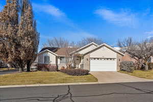 Single story home featuring a garage and a front lawn