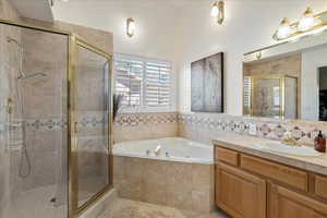 Bathroom featuring plus walk in shower and vanity