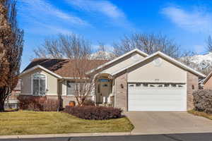 Ranch-style home with a garage and a front lawn