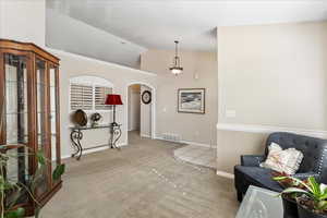 Living area featuring vaulted ceiling and carpet flooring