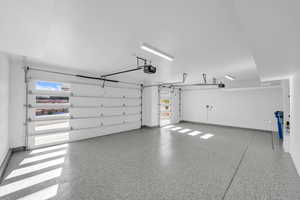 Garage with baseboards and a garage door opener