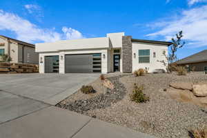 Contemporary home featuring a garage, driveway, and stucco siding